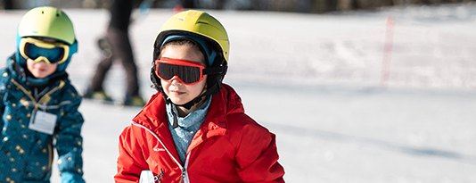 Enfants à ski, casqués, sur les pistes